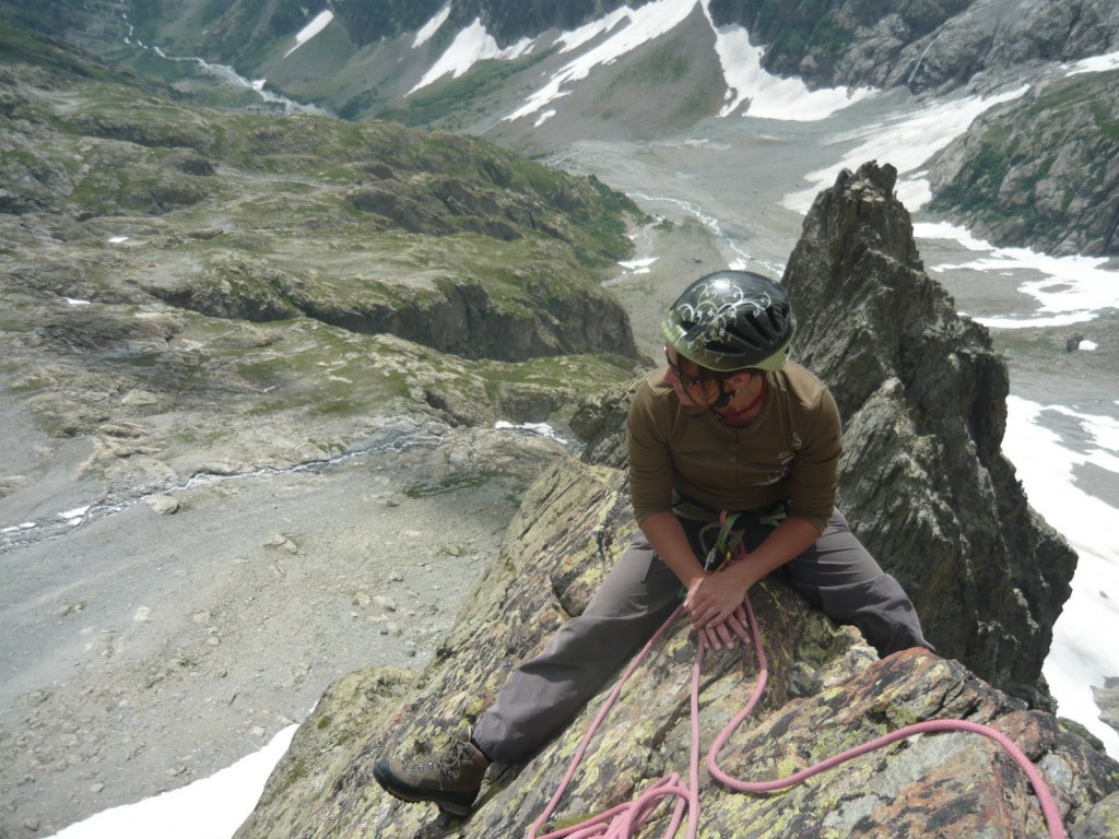 Elodie a cheval sur l’arête des dents de coste counier dans le massif des Ecrins.