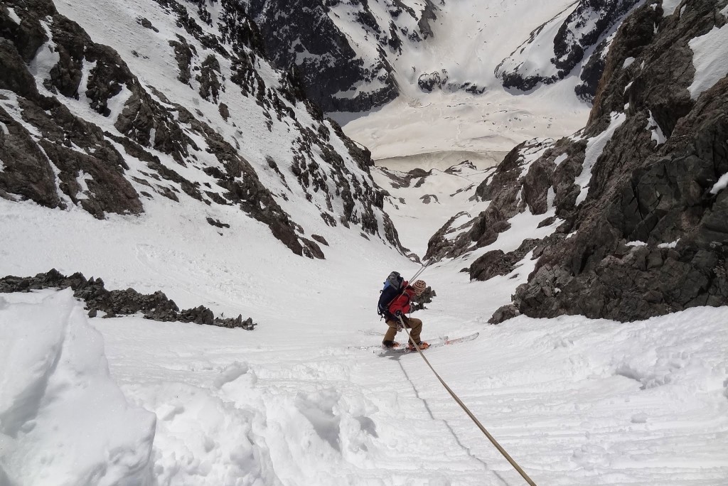 La guide de montagne descend en rappel l'entrée du couloir de la grande sagne lors de la traversée mord sud du col de la grande sagne.